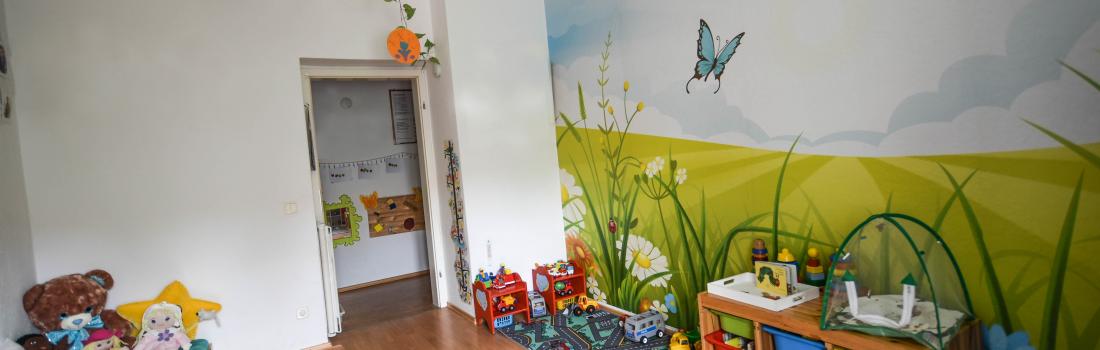 Buntes Kinderzimmer mit Spielzeug und Kuschelecke.