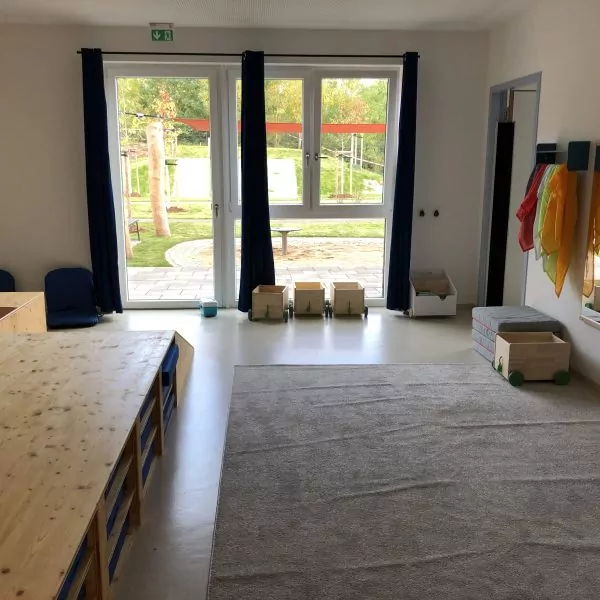 Raum, der mit einem großem Teppich und Spiegeln an der Wand sowie einem Holzpodest ausgestattet ist.