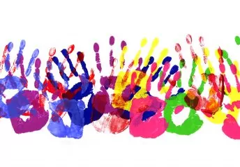 Bunte Farbabdrücke von Händen auf weißem Papier.