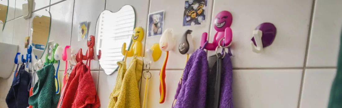 Bunte Handtücher hängen an Fliesen im Badezimmer.