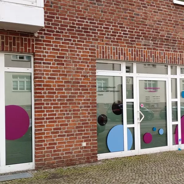 Außenansicht vom Familienzentrum Mockau, die Fenster sind mit bunten Kreisen dekoriert.
