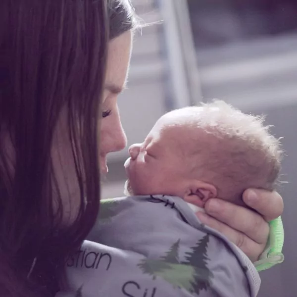 Eine Frau hält ihr kleines Baby im Arm, ihre Nasenspitzen treffen sich fast