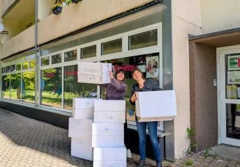 Cindy Deckert und Stephanie Schmutzer stapeln Umzugskartons vor dem Grünauer Familienzentrum.